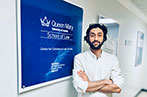 Amir Ghaffari scholarship winner Milad Gazerani in front of a Centre for Commercial Law Studies sign