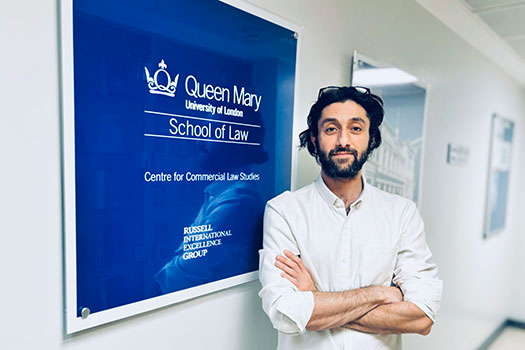 Amir Ghaffari scholarship winner Milad Gazerani in front of a Centre for Commercial Law Studies sign