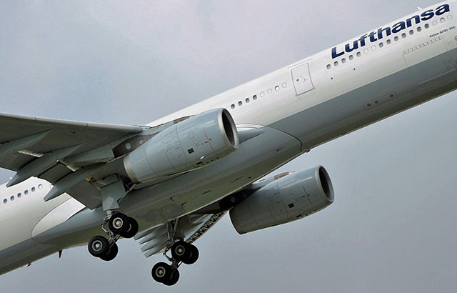 A commercial airplane taking off. It has the Lufthansa logo on the side.