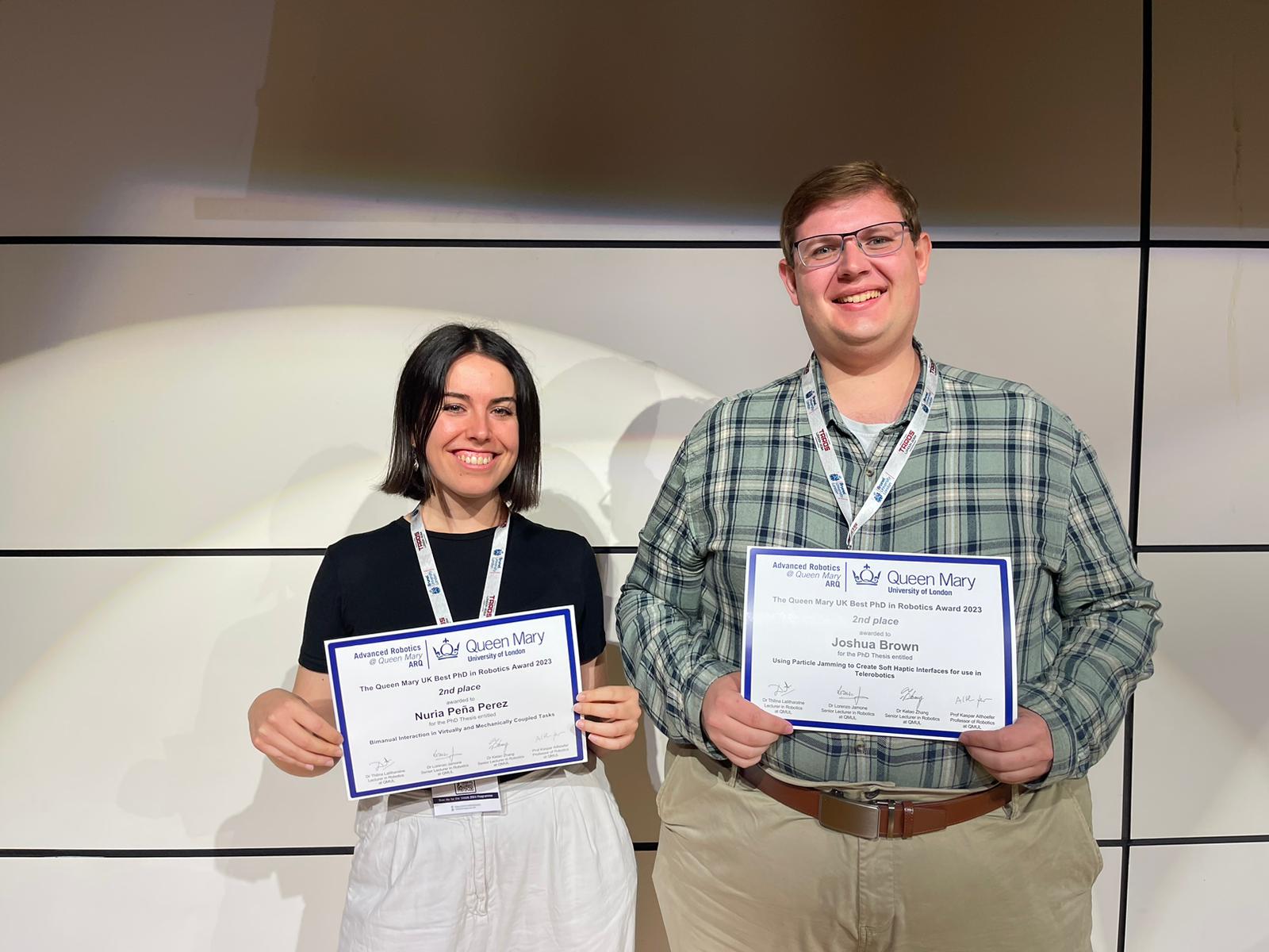 2 PhD students holding award