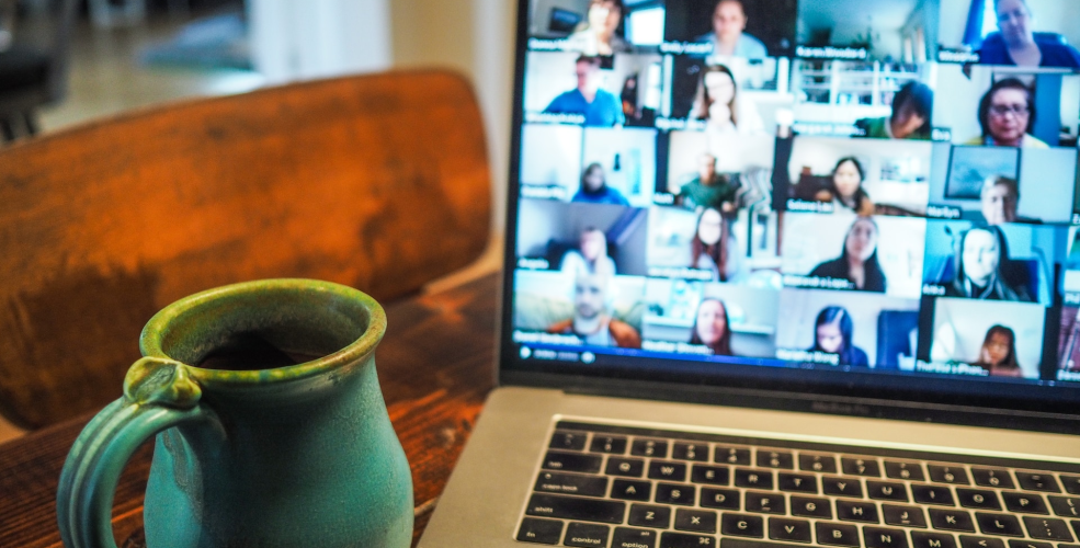 a macbook pro and a mug on a wooden table