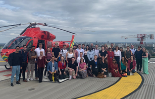 Students on the Trauma Sciences Summer School in front of the London Air Ambulance on the helipad of The Royal London Hospital