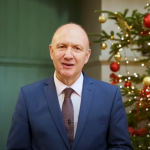 Colin Bailey, President and Principal of Queen Mary University of London, standing in front of a Christmas tree