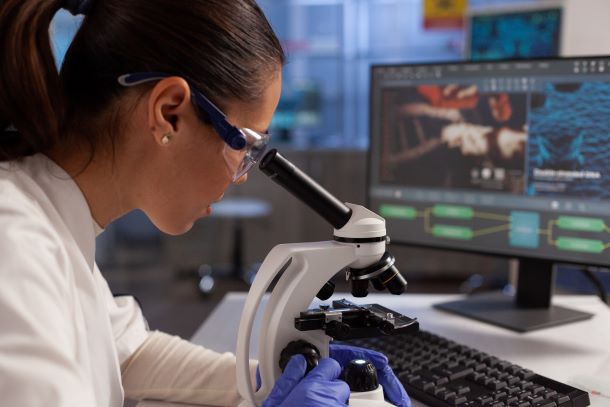 Biochemist working with microscope